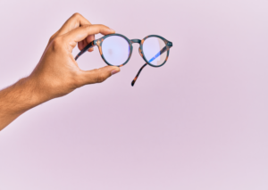 A person holding a pair of eyeglasses